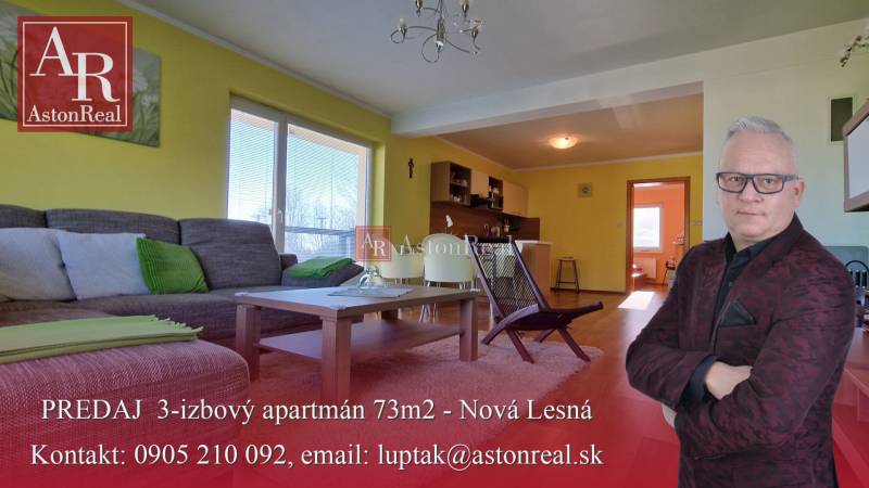 Wohnzimmer in einer Ferienwohnung mit Sofa, Tisch und Küchenzeile.