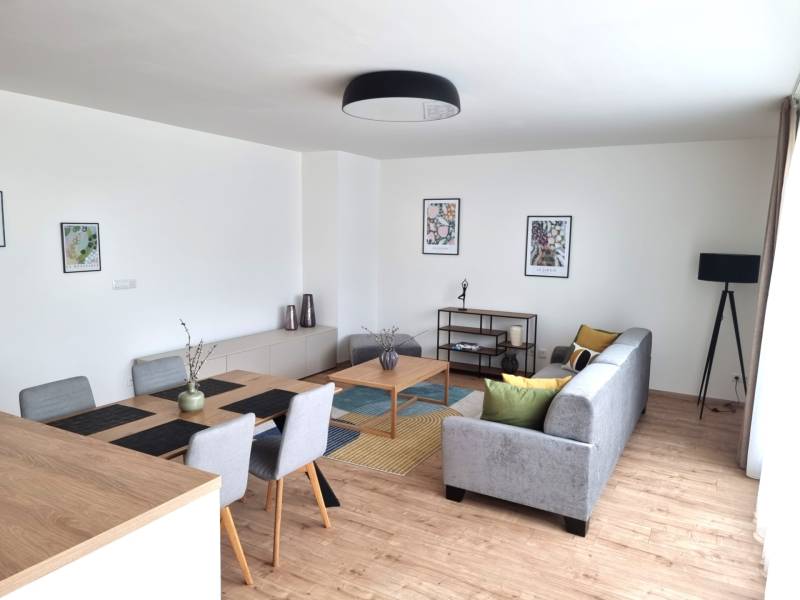 Wohnzimmer in einer 3-Zimmer-Wohnung mit Esstisch, Sofa und Dekorationen.