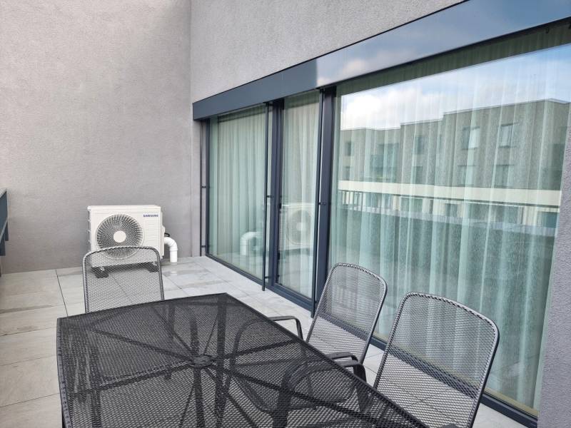 Balkon in einer 3-Zimmer-Wohnung mit Metallmöbeln und Klimaanlage.