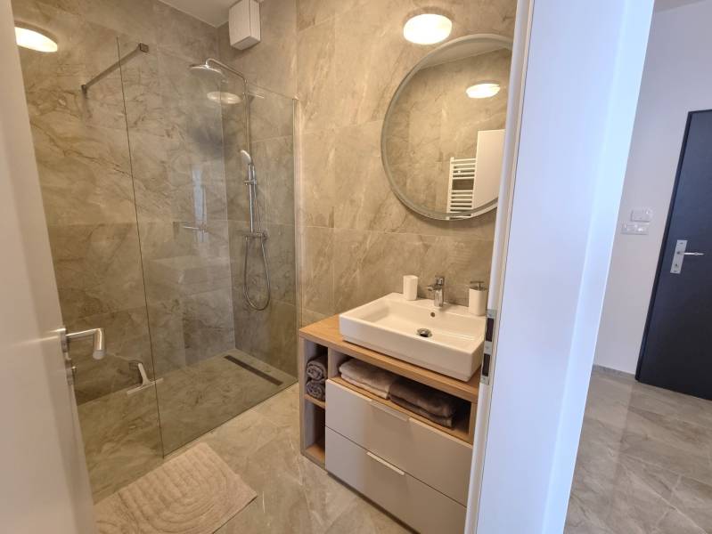 Badezimmer in einer 3-Zimmer-Wohnung mit Duschkabine und Waschtischunterschrank.