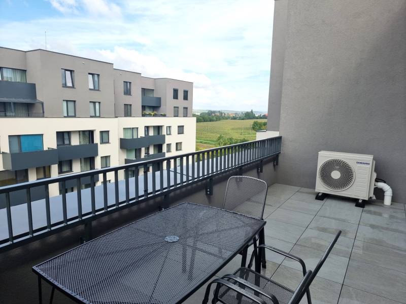 Die Terrasse der 3-Zimmer-Wohnung in der Pieskova-Straße in Nitra mit Blick auf die Umgebung.