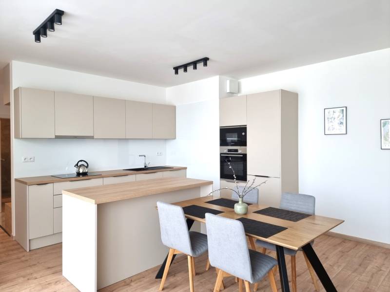 Küche in einer 3-Zimmer-Wohnung mit Holztisch und modernen Geräten.