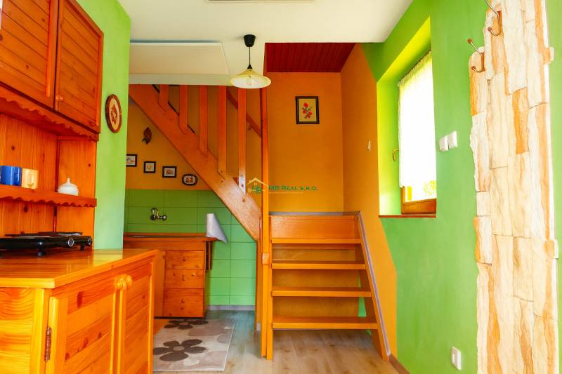 Bunte Inneneinrichtung der Hütte mit Treppe und Holzmöbeln.