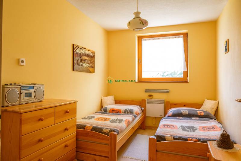 Ein Doppelzimmer in einer Hütte mit Holzmöbeln und einem Radio auf der Kommode.
