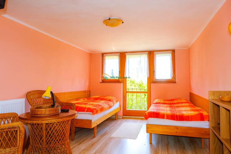 Ein Zweibettzimmer in einer Hütte mit Korbmöbeln und pastellfarbener Wandfarbe.