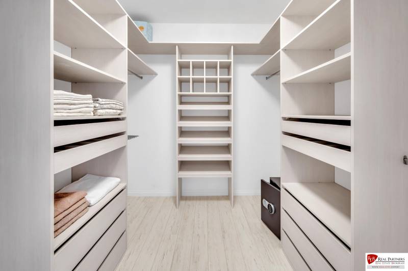 Ein Kleiderschrank mit hellen Regalen und Stauraum in einer 4-Zimmer-Wohnung.