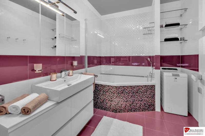 Badezimmer mit Dusche, Schrank und Waschmaschine in einer 4-Zimmer-Wohnung.