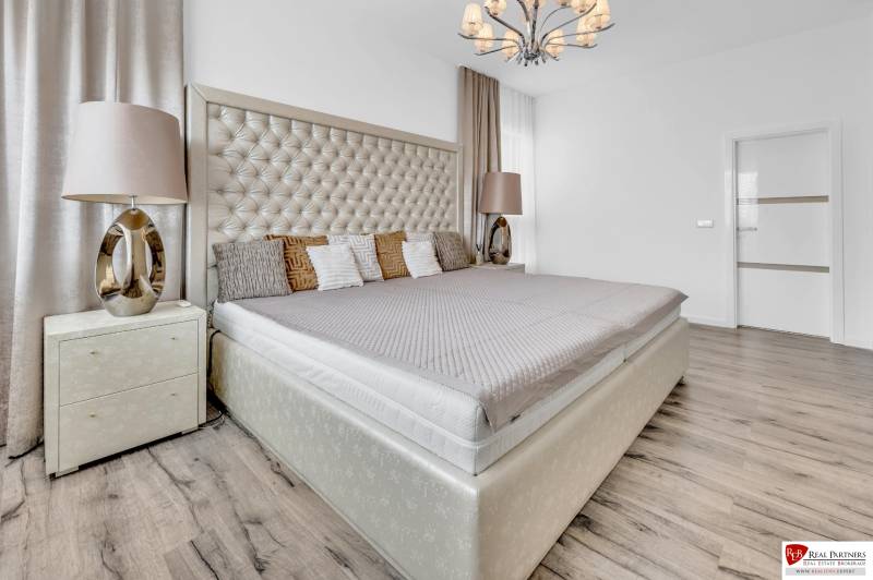 Luxuriöses Schlafzimmer mit großem Bett und stilvollem Kronleuchter in einer 4-Zimmer-Wohnung.