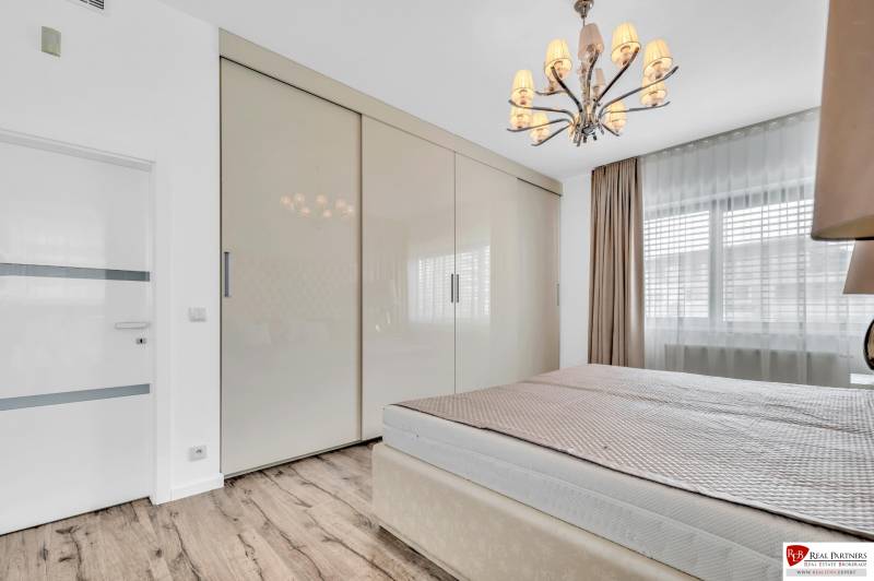 Schlafzimmer mit Kleiderschrank und Kronleuchter in einer 4-Zimmer-Wohnung.