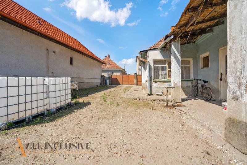 Der Hof des Einfamilienhauses in Jahodná mit einem Fahrrad und großen Wassertanks.