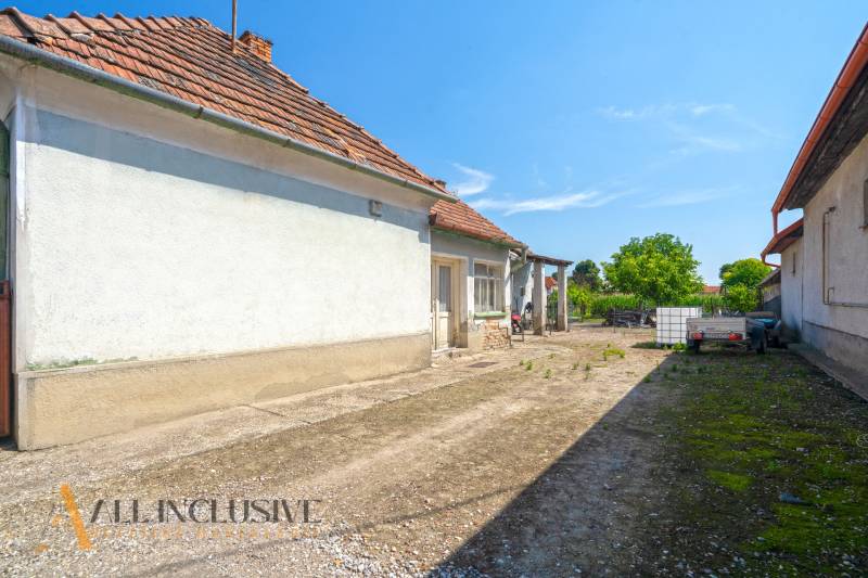 Höfe eines Einfamilienhauses in Jahodná mit Anhänger, Tank und Grünflächen.