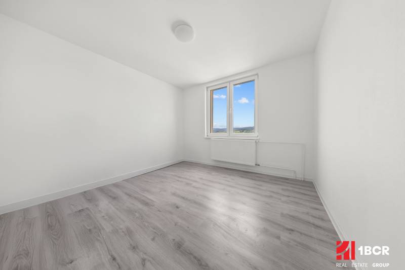 Ein leeres Zimmer in einer 2-Zimmer-Wohnung mit Fenster und Holzboden.