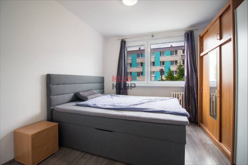Schlafzimmer mit Doppelbett, Kleiderschrank und Kommode in einer 2-Zimmer-Wohnung.