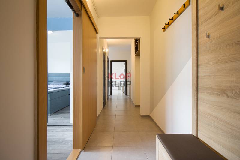Ein Flur mit hellen Wänden, Einbauschränken und Haken in einer 2-Zimmer-Wohnung.