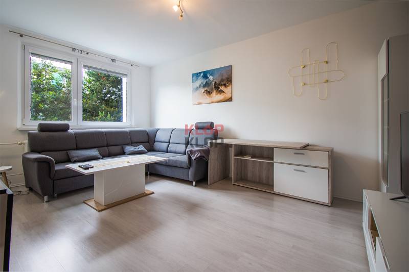 Wohnzimmer mit Ecksofa und Holzmöbeln in einer 2-Zimmer-Wohnung.