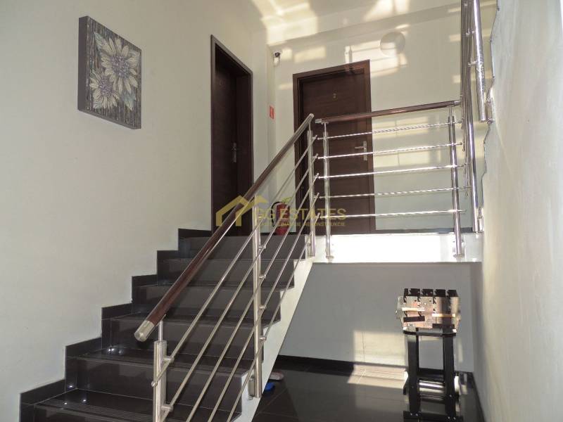 Eine Treppe mit modernem Geländer führt zu den Türen in einer 2-Zimmer-Wohnung.