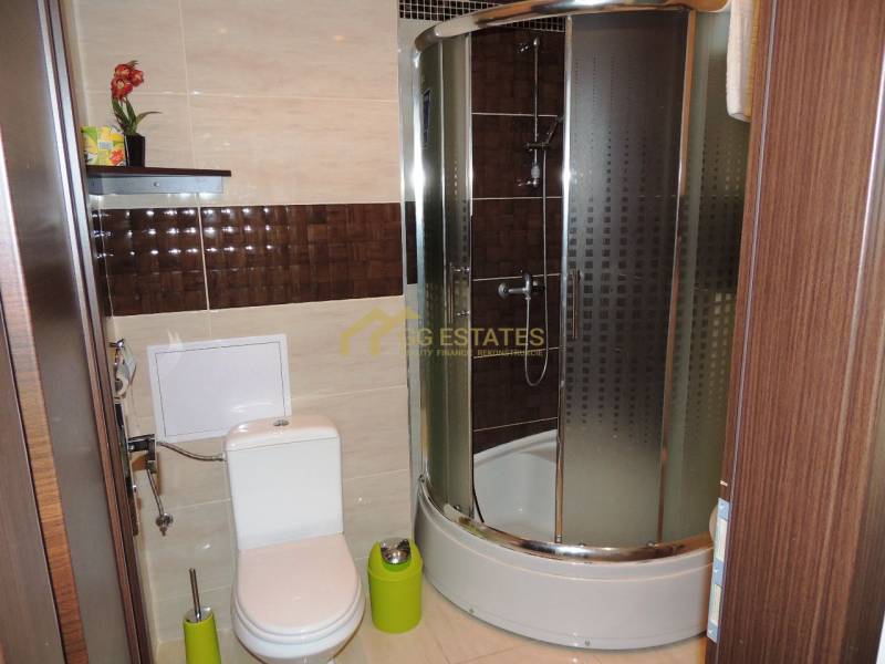 Badezimmer mit Toilette und Duschkabine in einer 2-Zimmer-Wohnung.
