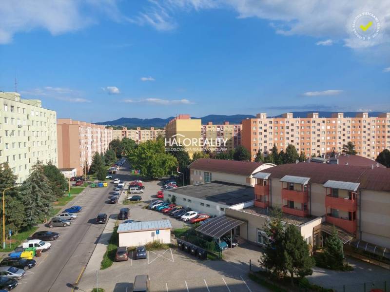 Blick auf die Wohnsiedlung in Prievidza mit Plattenbauten und geparkten Autos.