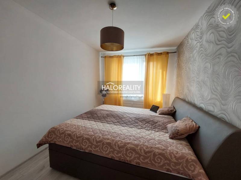Schlafzimmer mit gemusterten Tapeten und Vorhängen in einer 3-Zimmer-Wohnung.