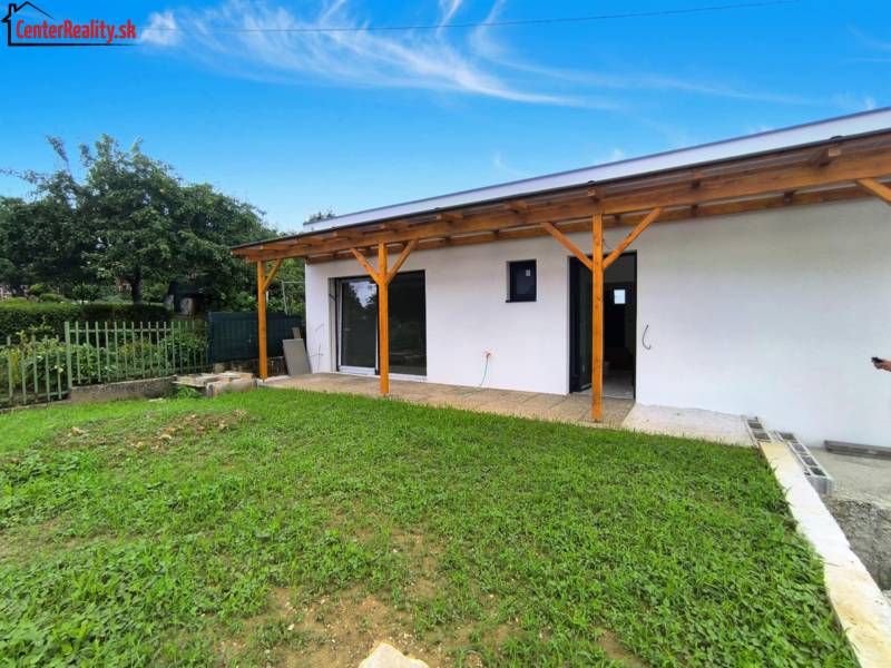 Ein Einfamilienhaus in Malé Kršteňany mit Garten und Holzterrasse.