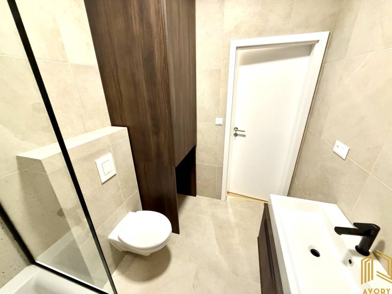 Ein Badezimmer in einem Studio-Apartment mit einer hängenden Toilette und einem modernen Waschbecken.