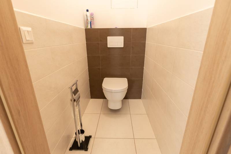 Separate Toilette in einer 3-Zimmer-Wohnung mit Fliesen und Sanitäranlagen.