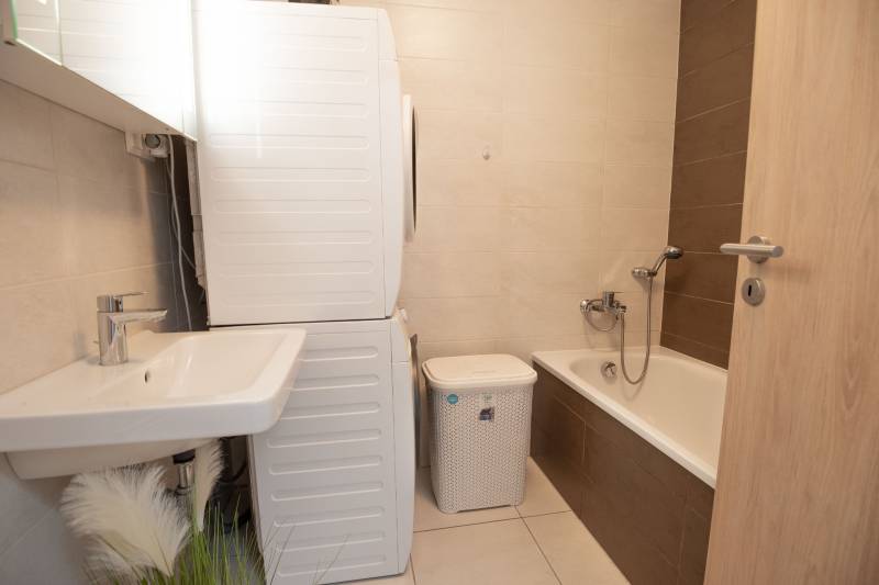 Badezimmer mit Badewanne, Waschbecken, Waschmaschine in einer 3-Zimmer-Wohnung.