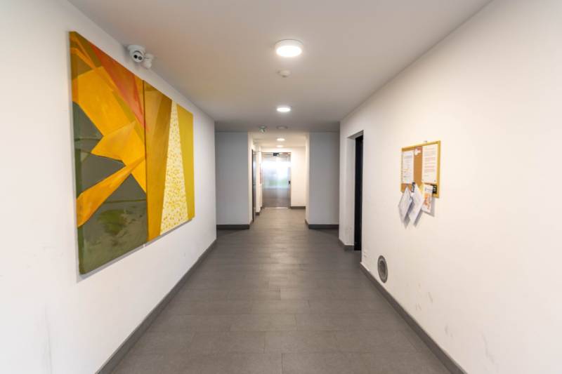 Flur mit abstraktem Gemälde in einer 3-Zimmer-Wohnung.