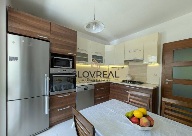 Küche in einer 4-Zimmer-Wohnung mit Holzschränken und Edelstahlgeräten.
