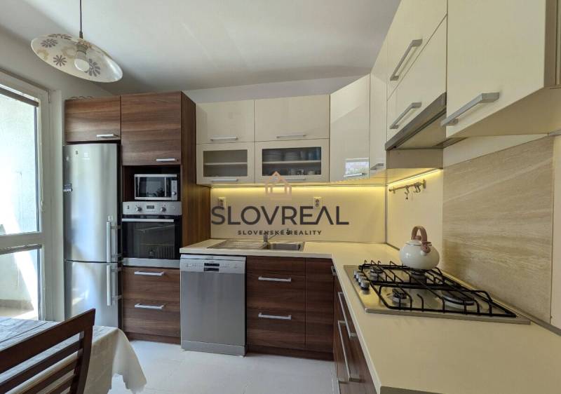 Küche in einer 4-Zimmer-Wohnung mit Holzschränken, Herd und Kühlschrank.