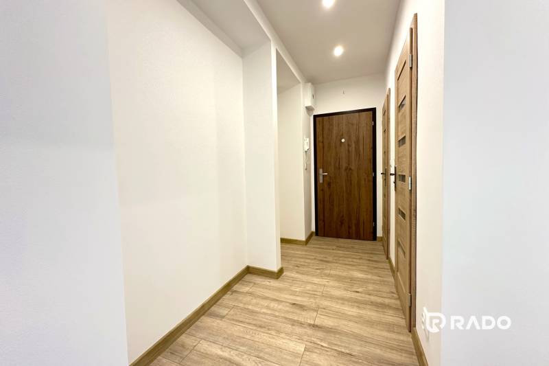 Der Flur in der 2-Zimmer-Wohnung mit Holzboden und weißen Wänden.