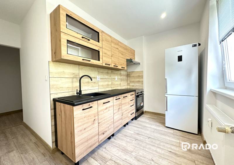 Küche in einer 2-Zimmer-Wohnung mit Holzschränken und moderner Ausstattung.