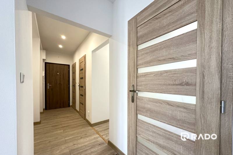 Der Flur in der 2-Zimmer-Wohnung mit Holztüren und Laminatboden.