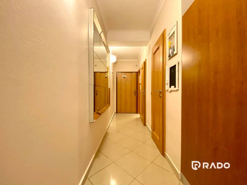 Der Flur in der 3-Zimmer-Wohnung mit Holztüren und einem Spiegel an der Wand.