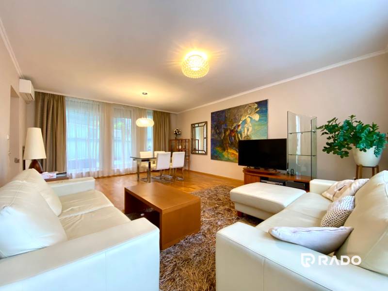 Wohnzimmer in einer 3-Zimmer-Wohnung mit hellen Sofas, Fernseher und Esstisch.