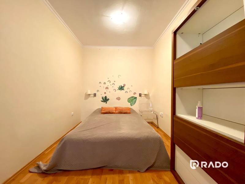 Schlafzimmer in einer 3-Zimmer-Wohnung mit einem Kleiderschrank und Wanddekorationen.