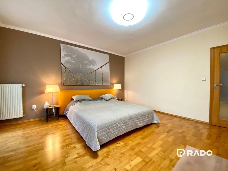 Schlafzimmer in einer 3-Zimmer-Wohnung mit Holzboden und einem großen Bild von einer Brücke.