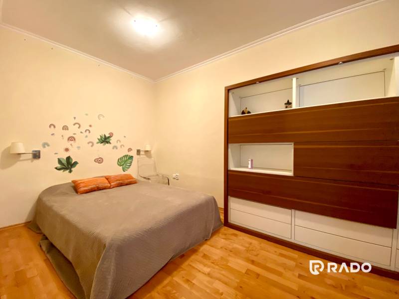 Schlafzimmer mit Bett, Wanddekoration und Einbauschrank in einer 3-Zimmer-Wohnung.