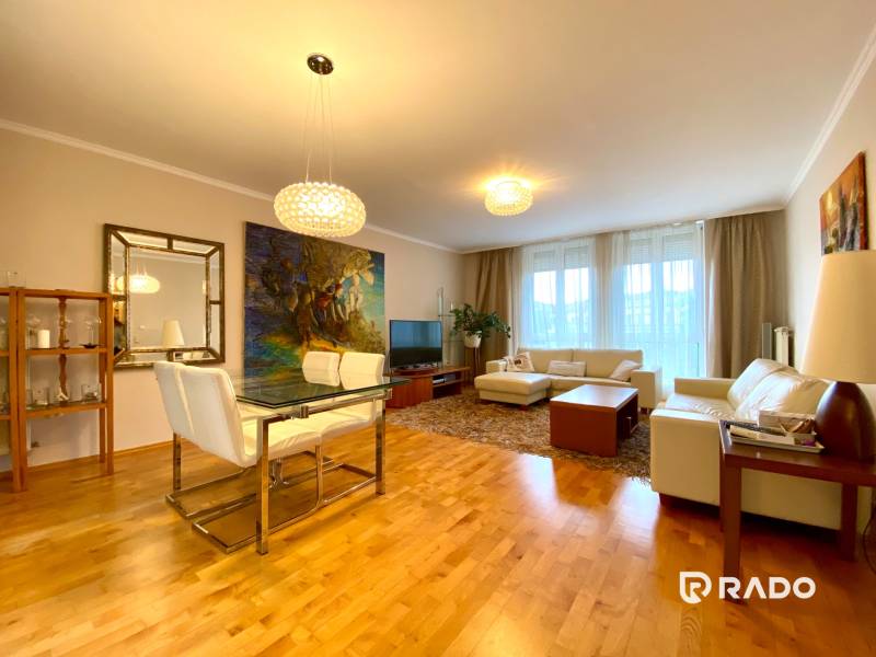 Wohnzimmer in einer 3-Zimmer-Wohnung mit Holzboden, bequemer Couch und Esstisch.