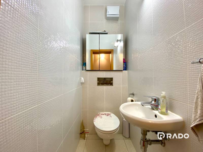 Badezimmer mit Spiegel, Waschbecken und Toilette in einer 3-Zimmer-Wohnung.