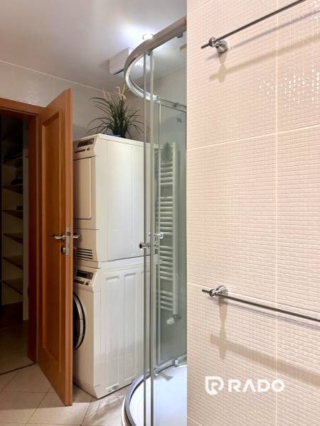 Badezimmer mit Dusche, Waschmaschine und Trockner in einer 3-Zimmer-Wohnung.