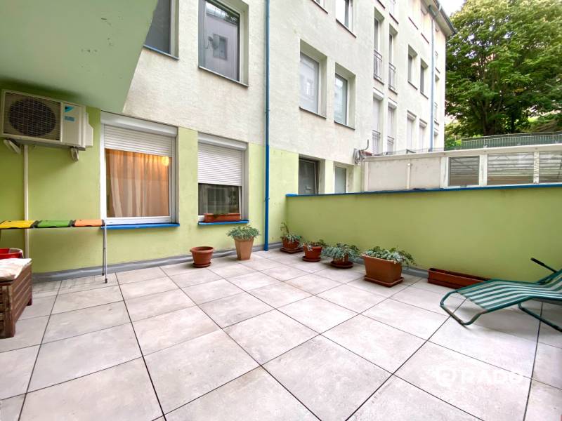 Terrasse mit Blumentöpfen und Liegestuhl in einer 3-Zimmer-Wohnung.