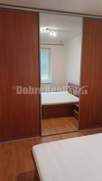 Schlafzimmer mit Holzboden und Schrank in einer 2-Zimmer-Wohnung.