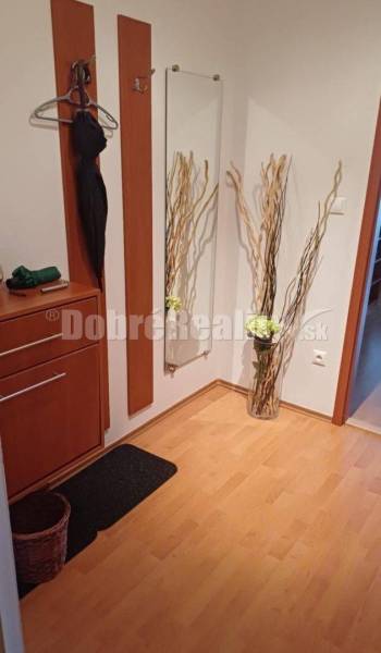 Flur mit Holzboden, Spiegel und Dekoration in einer Vase in einer 2-Zimmer-Wohnung.