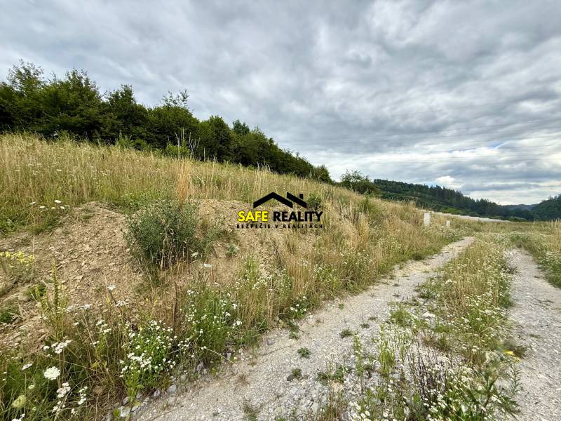 Grundstücke - Wohnen in Divinka mit Gras, Bäumen und einer Straße unter wolkigem Himmel.