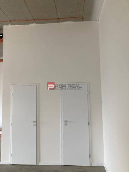 Doppelte weiße Türen in Geschäftsräumen mit Betondecke.