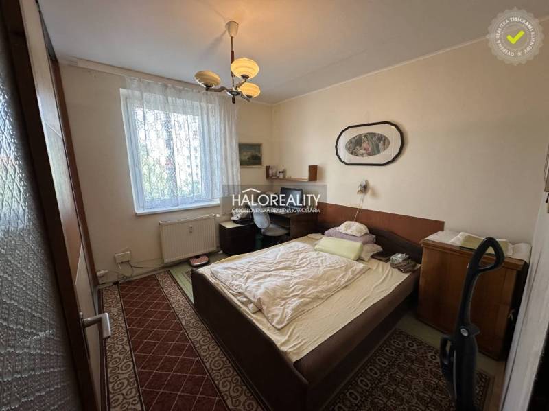 Schlafzimmer in einer 3-Zimmer-Wohnung mit Bett, Bild und Teppichen, geeignet zum Wohnen.