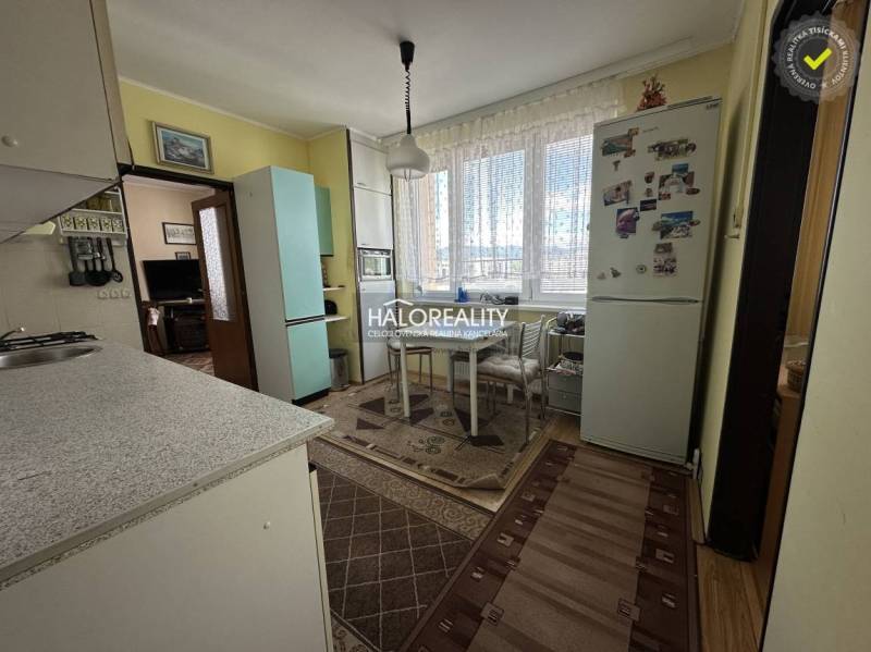 Küche in einer 3-Zimmer-Wohnung mit Esstisch, Kühlschrank und Gasherd.