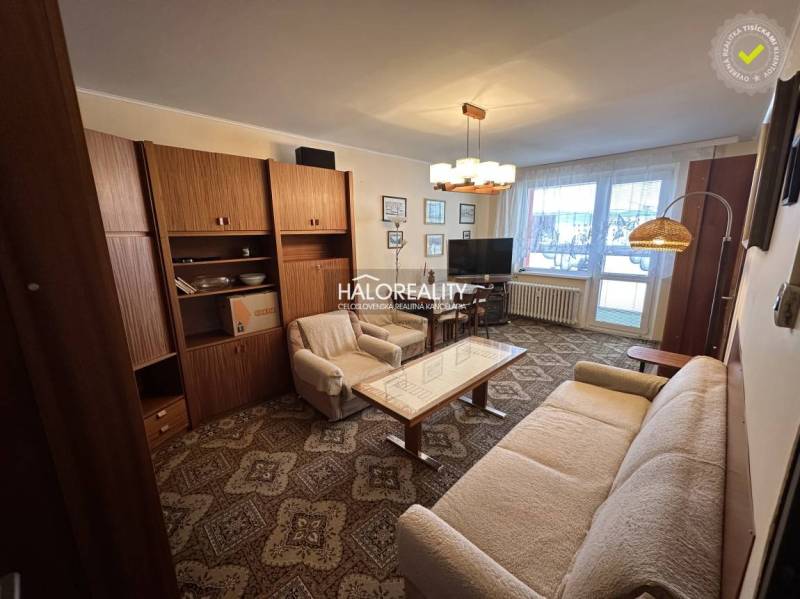 Stilvolles Wohnzimmer in einer 3-Zimmer-Wohnung mit Sofa, Sessel und Vorhängen.