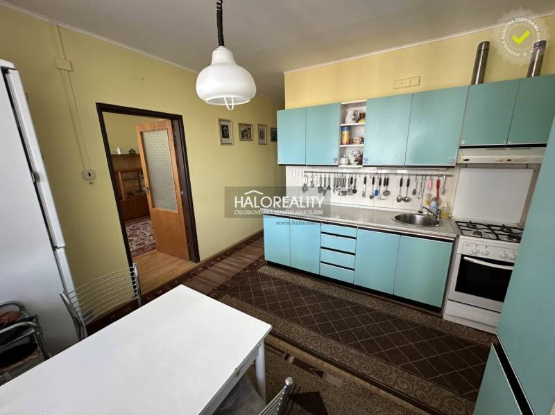 Küche in einer 3-Zimmer-Wohnung mit einfacher Einrichtung und gelben Wänden.